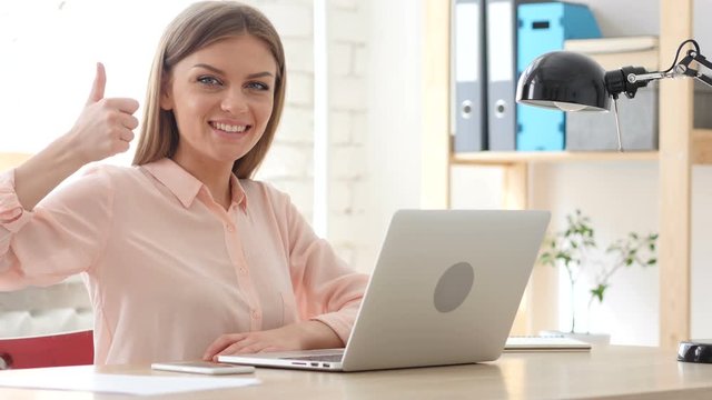 Thumbs Up by Creative Woman Sitting in Office