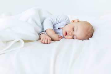 Close-up portrait of adorable baby boy sleeping in bed, 1 year old baby concept