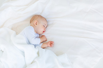 Close-up portrait of adorable baby boy sleeping in bed, 1 year old baby concept - Powered by Adobe