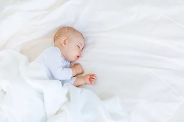Fototapeten Close-up portrait of adorable baby boy sleeping in bed, 1 year old baby concept © LIGHTFIELD STUDIOS