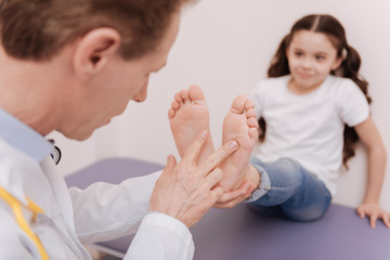 Thorough determined specialist comparing the state of the feet