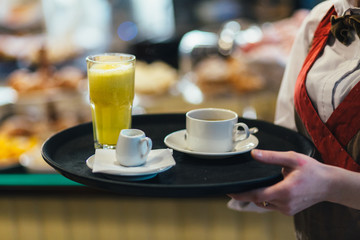 Fototapeta na wymiar Waitress holding tray with coffee, milk and orange juice.service Service And Beverages Concept .