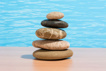 Fototapeta na wymiar Relaxing on the pool, stack of stones. Zen and spa concept