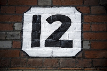 Number twelve hand painted on plaster background