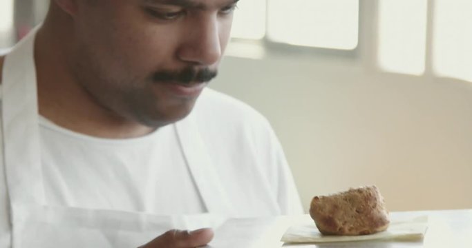black chef looks at pastry
