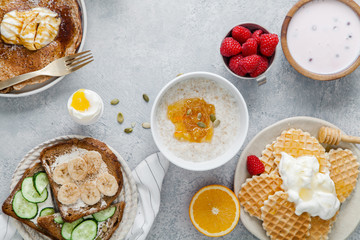 Morning atmosphere. Healthy breakfast with porridge, oatmeal, pancakes, lots of berries and snacks on blue rustic background. Copy space