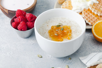 Morning oatmeal with homemade orange confiture and raspberry