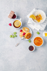 Morning atmosphere. Healthy breakfast with porridge, oatmeal, pancakes, lots of berries and snacks on blue rustic background. Copy space