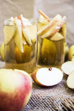 Apple cider with slices of apples in transparent glasses on a wooden board