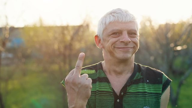 Smiling Man showing the middle finger