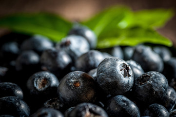 blueberries on wooden background, Freshly blueberries in wooden bowl. Juicy and fresh blueberries with green leaves on wood table. Blueberry antioxidant. Concept for healthy eating and nutrition