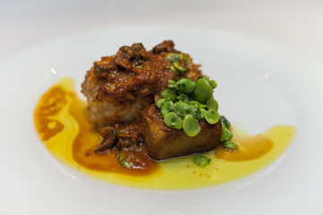Monkfish with red sauce and broad ben in a dish.