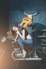 Fototapeta na wymiar girl model with guitar sitting on motorcycle