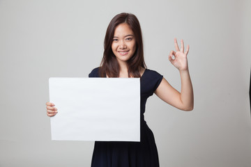 Fototapeta premium Young Asian woman show OK with white blank sign.