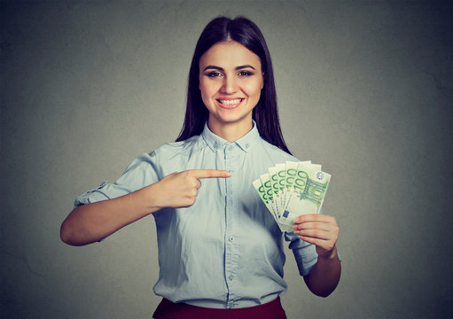 Money. Business woman looking at camera pointing at cash