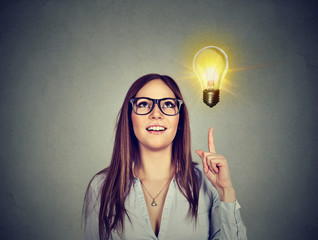 Woman pointing at bright light bulb. Success growing business concept