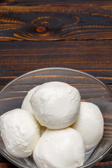 Mozzarella In a glass plate on wooden background