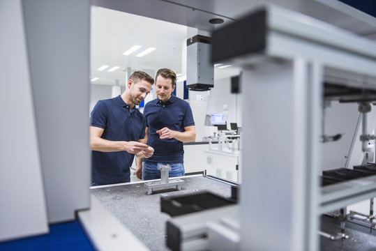 Two men at a machine in testing instrument room