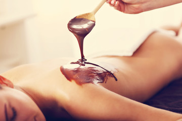 Beautiful woman getting chocolate massage in spa
