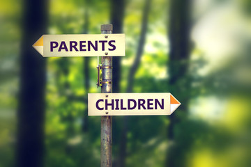 Signpost in a park with arrows pointing in two opposite directions Children and Parents.