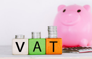VAT Concept with wooden block with stacked coins