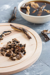 Mushroom soup cooking. Slicing mushrooms on a wooden board. Soaking mushrooms.