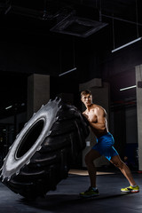 Obraz na płótnie Canvas training - man flipping tire in gym