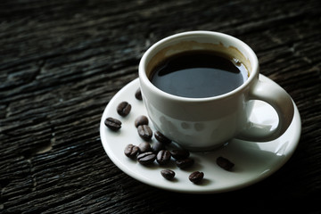 Black coffee in white cup On the old wood table Vintage tone