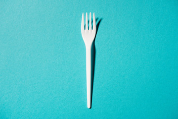 top view of white plastic fork isolated on blue