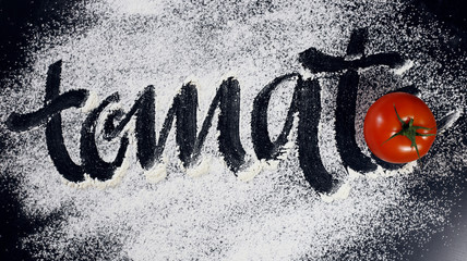 The inscription on the flour. Tomato. Black background