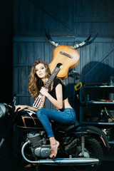 Fototapeta na wymiar Pretty girl model with guitar sitting on motorcycle