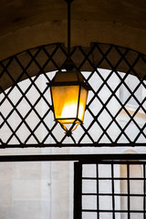 zabytkowa latarnia na tle kraty budynku