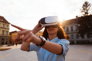 Woman gets experience of using VR-glasses virtual reality headset in the city