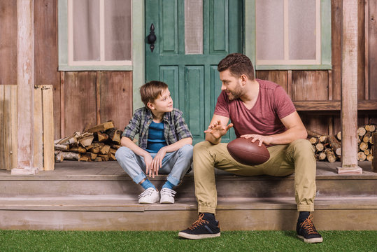 Young Father With Little Son Sitting On Porch At Backyard, Dad And Son Playing