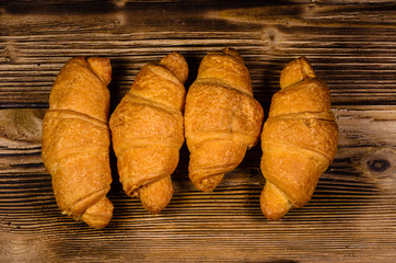 Fresh croissants on wooden table. Top view