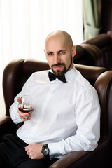 Beautiful male drinking Cognac in the restaurant.