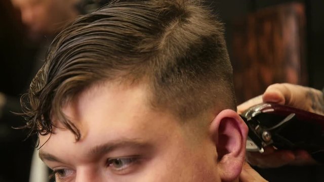 Man Barber Cuts the Client's Hair with a Clipper Hair in The Hairdresser's