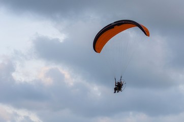 Miniplane Paramotor glider flying in the sky, adventure man active extreme sport.
