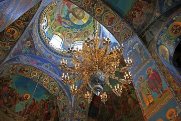 Fototapeta na wymiar Mosaics and an ornate chandelier in the interior of the Church of the Savior on Spilled Blood