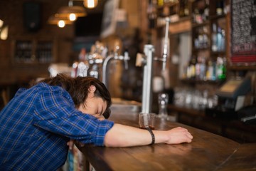 Man leaning on counter in pub