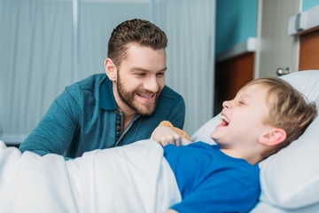 Obraz premium happy dad and son having fun together in hospital chamber