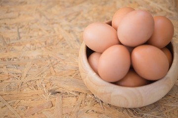 Egg in a wooden bowl on wooden table