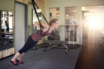 Junge blonde Frau macht Suspensiontraining