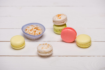 Variety of fresh macarons on wooden table.  sweets background