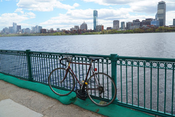 single bicycle in front of railing on the bank of Charles river in Boston