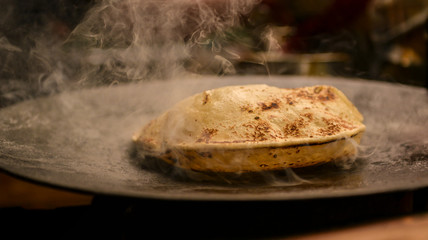 Roti or Indian Bread being baked on a pan
