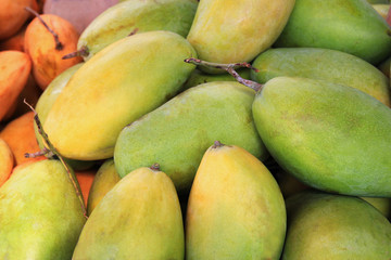 Travel to island Koh Lanta, Thailand. The ripe tasty yellow and green mango close up on a market.