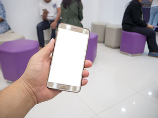 Man hand holding touch screen smart phone with white blank empty screen (ISOLATED), blurred fast food restaurant for background.