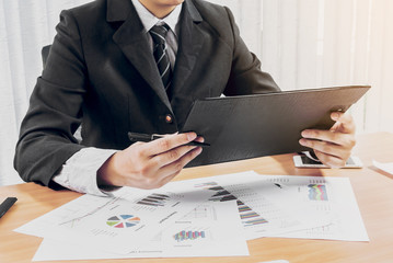 Businessman working and holding pen on business graph information