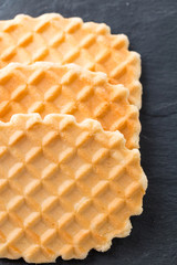 Top view on pile of waffles stacked on slate plate.